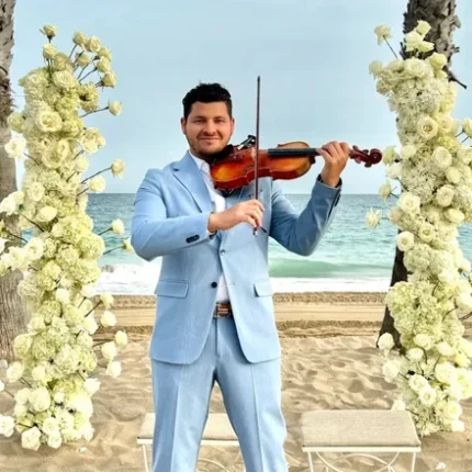 "Violista tocando en vivo durante una celebración de Quinceañera Barcelona, con un salón decorado elegantemente para el evento.