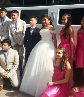 "Limusina Hummer con la quinceañera, su dama de honor y amigos posando para la foto antes de la celebración."