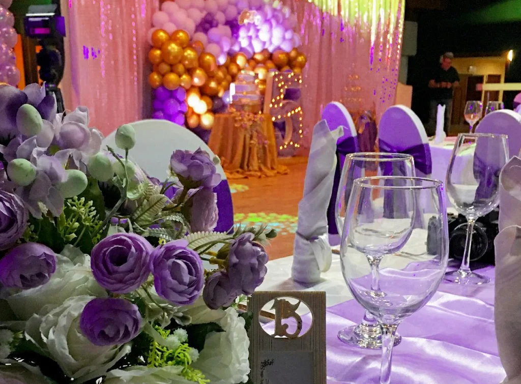 imagen ilustra un a mesa decorativa con su mantel y flores para la fiesta quinceañera